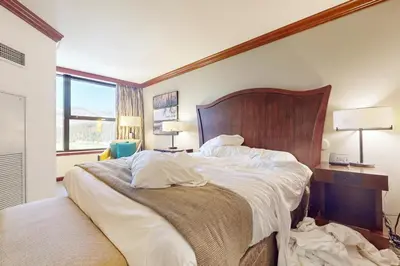 a bedroom with a large bed with a wooden headboard at Resort at Squaw Creek's 806 & 808 in Olympic Valley