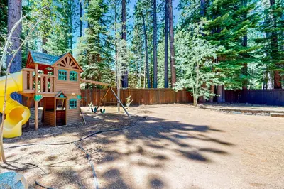 a playground with a small house and a slide at Cochise Charms in South Lake Tahoe