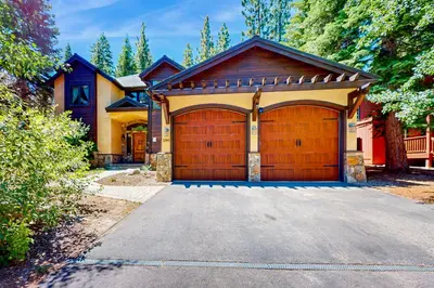 a house with a wooden garage with a driveway at Cochise Charms in South Lake Tahoe