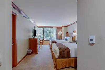 a hotel room with two beds and a television at Resort at Squaw Creek's 605 in Olympic Valley