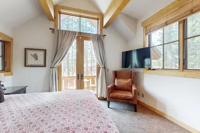 a bedroom with a bed and a tv and a chair at Mount Olympia Oasis in South Lake Tahoe