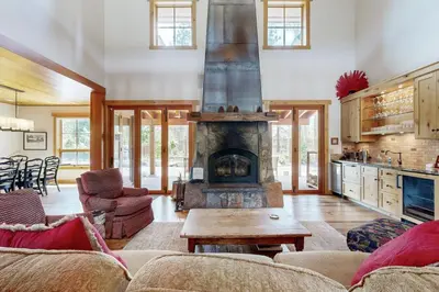 a living room with a fireplace and a table at Mount Olympia Oasis in South Lake Tahoe