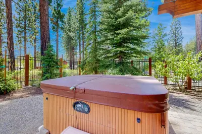 a hot tub sitting on the ground next to a fence at Mount Olympia Oasis in South Lake Tahoe