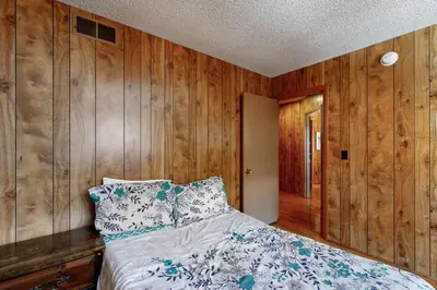 a bedroom with wood paneled walls and a bed at Pineland Escape in Tahoe City