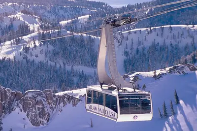 a gondola flying over a snow covered mountain at Resort at Squaw Creek's 317 & 319 in Olympic Valley