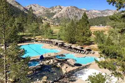 an aerial view of a resort pool with mountains in the background at Resort at Squaw Creek's 521 in Olympic Valley