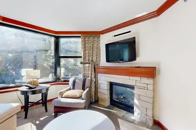 a living room with a fireplace and a tv at Resort at Squaw Creek's 521 in Olympic Valley