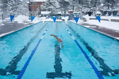 a person swimming in a swimming pool in the snow at Tahoe Donner Snow Globe in Truckee
