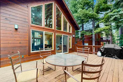 a patio with a table and chairs on a wooden deck at Tahoe Donner Snow Globe in Truckee