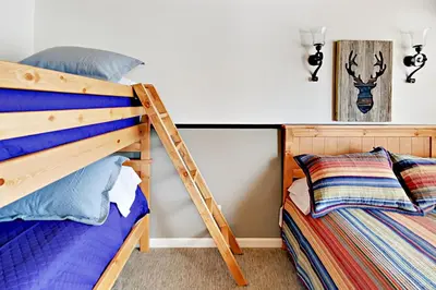 a bedroom with a bunk bed and a ladder next to a pillow at Cove 141 in South Lake Tahoe