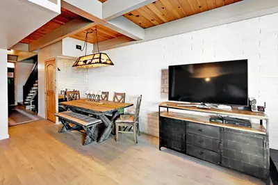 a dining room with a table and a large tv at Cove 141 in South Lake Tahoe