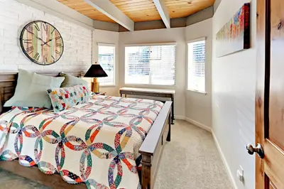 a bedroom with a bed and a clock on the wall at Cove 141 in South Lake Tahoe