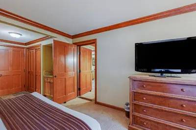 a bedroom with a flat screen tv and a dresser with a bed at Resort at Squaw Creek's 605 & 607 in Olympic Valley