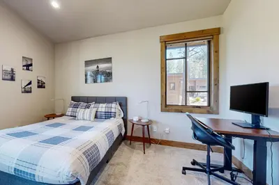 a bedroom with a bed and a desk with a computer at Henness Haven in Truckee