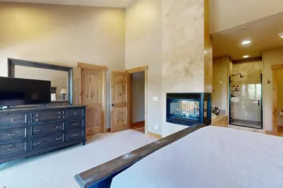 a bedroom with a bed and a tv and a fireplace at Walk-Friendly Truckee House in Truckee