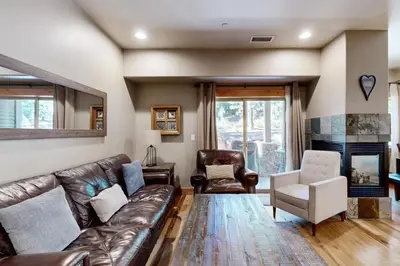 a living room with a leather couch and a chair at Walk-Friendly Truckee House in Truckee