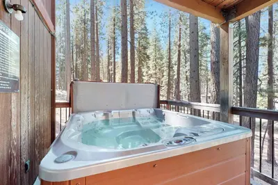a jacuzzi tub on a deck with trees at High Meadows Retreat in South Lake Tahoe