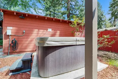 a red building with a tub next to a fence at Manzanita Holiday 5 in South Lake Tahoe