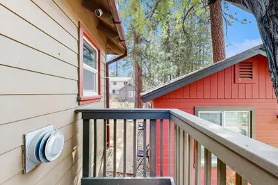 a balcony of a red house with a tree at Manzanita Holiday 2 in South Lake Tahoe