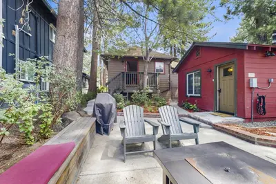 a patio with chairs and a table and a red house at Manzanita Holiday 2 in South Lake Tahoe