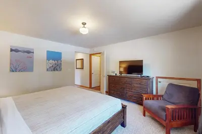a bedroom with a bed and a chair and a television at Gold Dust Escape in South Lake Tahoe