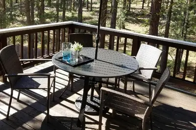 a table on a deck with chairs and an umbrella at Gold Dust Escape in South Lake Tahoe