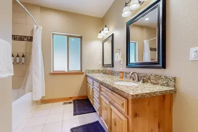 a bathroom with a sink and a tub and a mirror at Wagon Wood Retreat in South Lake Tahoe