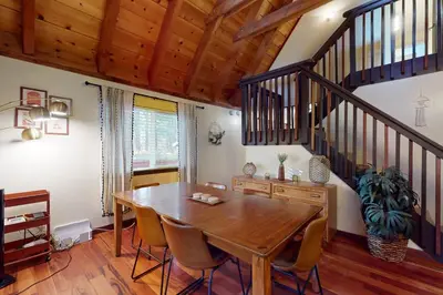 a dining room with a wooden table and a staircase at Genoa Haven in South Lake Tahoe