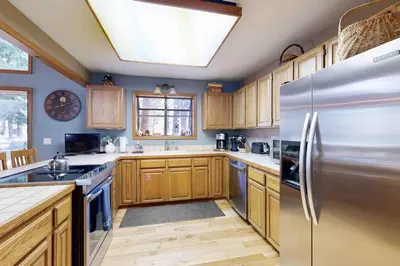 a kitchen with wooden cabinets and a stainless steel refrigerator at Schussing Escape in Truckee