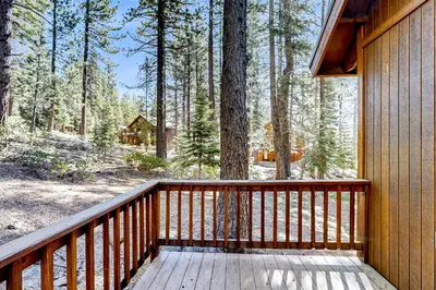 a wooden deck with a view of a forest at Lausanne Getaway in Truckee