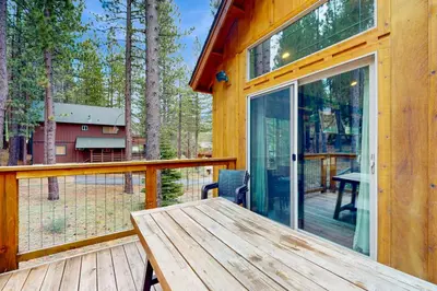 a wooden table on a deck with a glass door at Luxury Mountain Retreat in South Lake Tahoe
