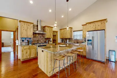 a kitchen with wooden cabinets and a large island with bar stools at Luxury Mountain Retreat in South Lake Tahoe