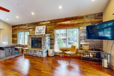 a living room with a fireplace and a flat screen tv at Luxury Mountain Retreat in South Lake Tahoe