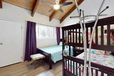 a bedroom with a bunk bed and a room with a window at Ski Run Village in South Lake Tahoe