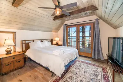 a bedroom with a bed with a ceiling fan and a tv at Lakeview Manor in South Lake Tahoe