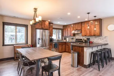a kitchen with wooden cabinets and a wooden table at Lakeview Manor in South Lake Tahoe