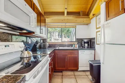 a kitchen with a sink and a white refrigerator at Alpine Retreat in Truckee