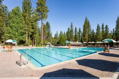 a large swimming pool in a resort with trees at Alpine Retreat in Truckee