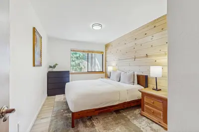 a bedroom with a bed and a wooden wall at Alpine Retreat in Truckee