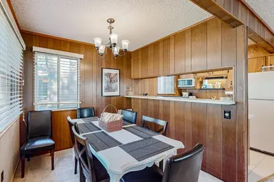 a dining room with a table and chairs and a refrigerator at Sky Meadows Charmer in South Lake Tahoe