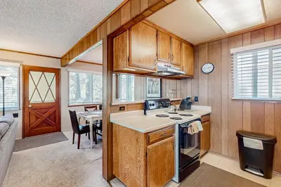 a kitchen with wooden cabinets and a sink and a table at Sky Meadows Charmer in South Lake Tahoe