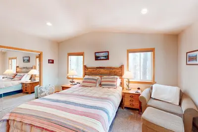 a bedroom with a large bed and a chair at Falcon Point Manor in Truckee