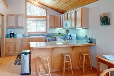 a kitchen with wooden cabinets and a counter with stools at Falcon Point Manor in Truckee