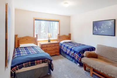 a bedroom with two beds and a couch and a window at Falcon Point Manor in Truckee