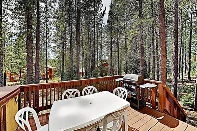 a deck with white chairs and a grill on it at Falcon Point Manor in Truckee
