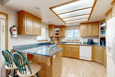 a kitchen with wooden cabinets and a counter with chairs at Oregon Oasis in South Lake Tahoe