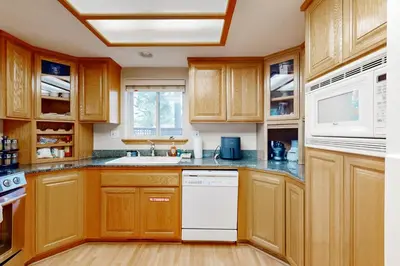 a kitchen with wooden cabinets and a white dishwasher at Oregon Oasis in South Lake Tahoe