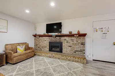 a living room with a brick fireplace with a flat screen tv at Charming Lake Tahoe Cabin in Carnelian Bay