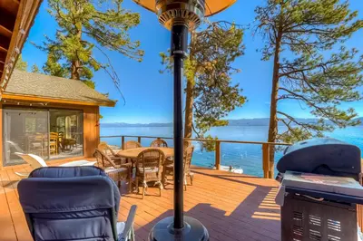 a deck with a table and chairs and a view of the water at Cascade Charms in South Lake Tahoe