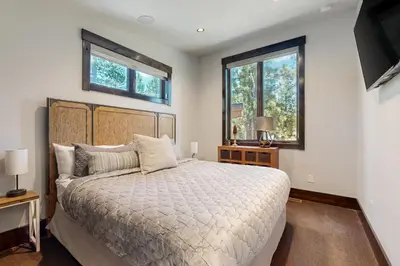 a bedroom with a large bed and two windows at Henness Escape in Truckee